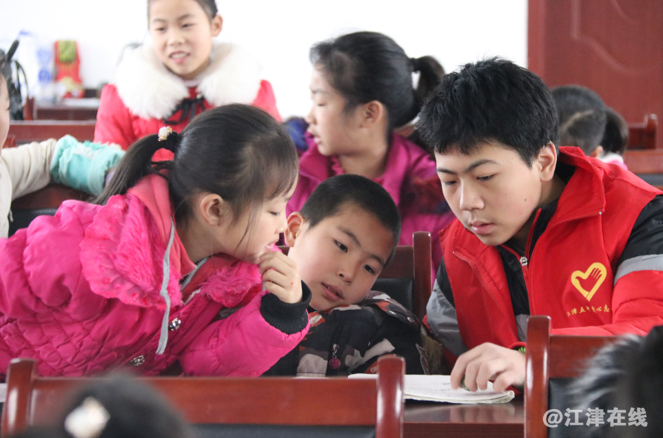 图为江津第五中心志愿者给孩子们辅导作业.png